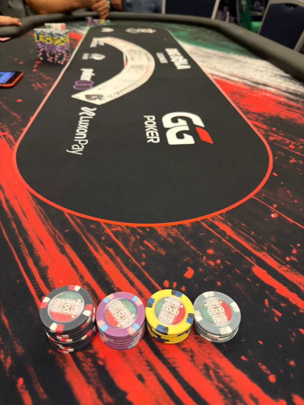 Fichas de Big Bola Casinos sobre el tapete de la mesa de torneo